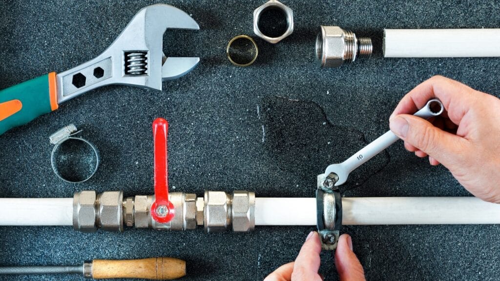Plumber repairing a pipe valve with an adjustable wrench in Altamonte Springs