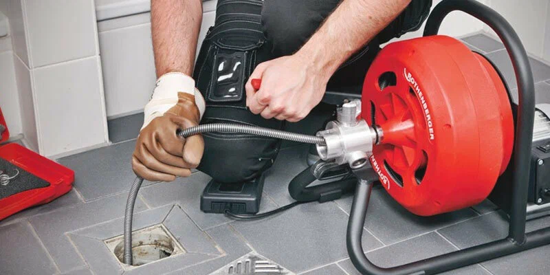 Plumber using a drain-cleaning machine in Altamonte Springs