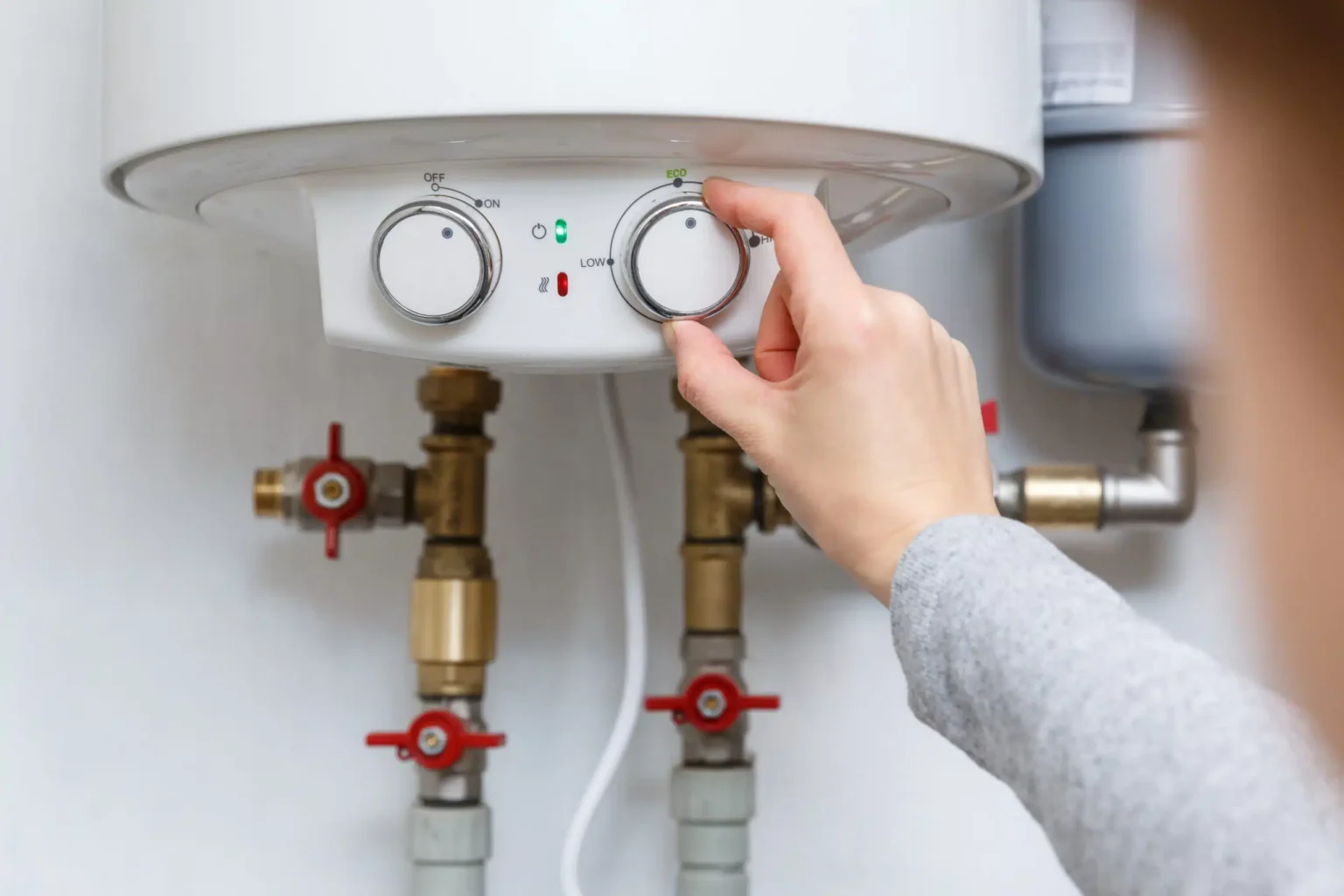 Homeowner adjusting the temperature controls on a water heater in Altamonte Springs